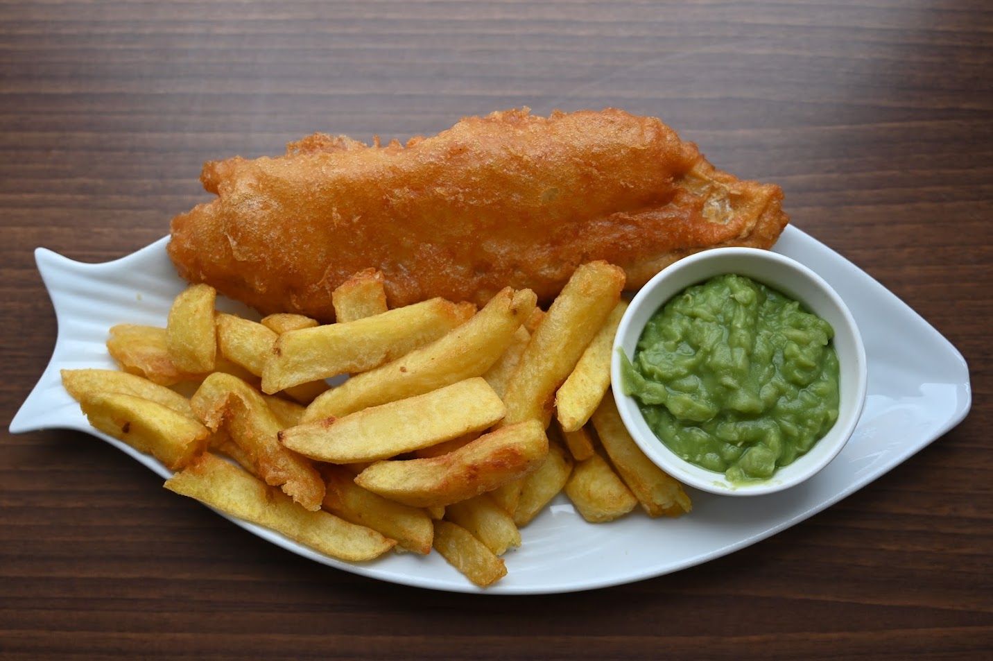 A hot portion of freshly fried battered cod, golden chips and mushy peas from Silktown Fryer